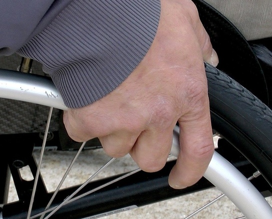 Hand eines Rollstuhlfahrers am Reifen